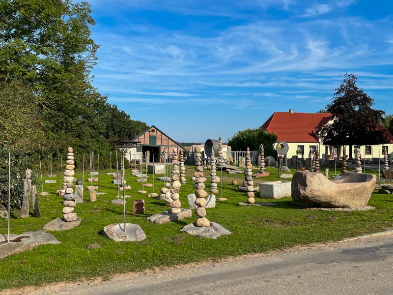 Der Hofplatz von Lei - Einfach & Anders mit Feldsteinbrunnen im Vordergrund.